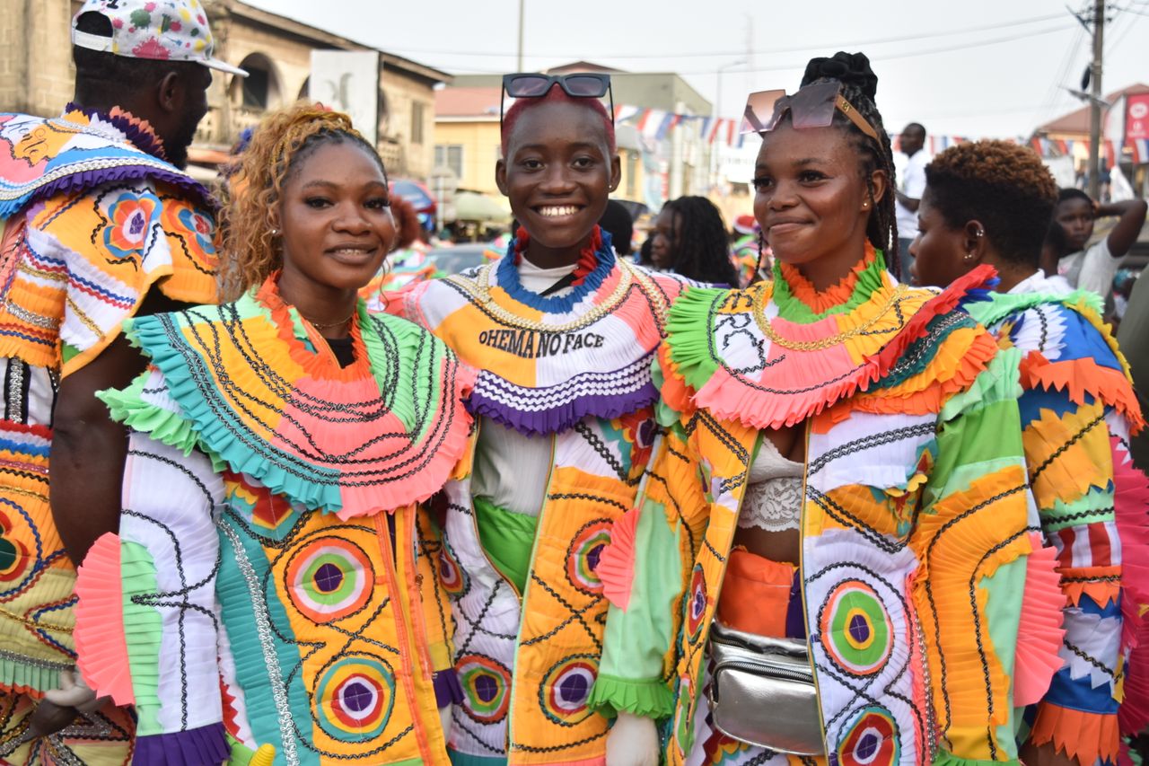 Vibrant costumes and joyful expressions captured during an outdoor festival parade.